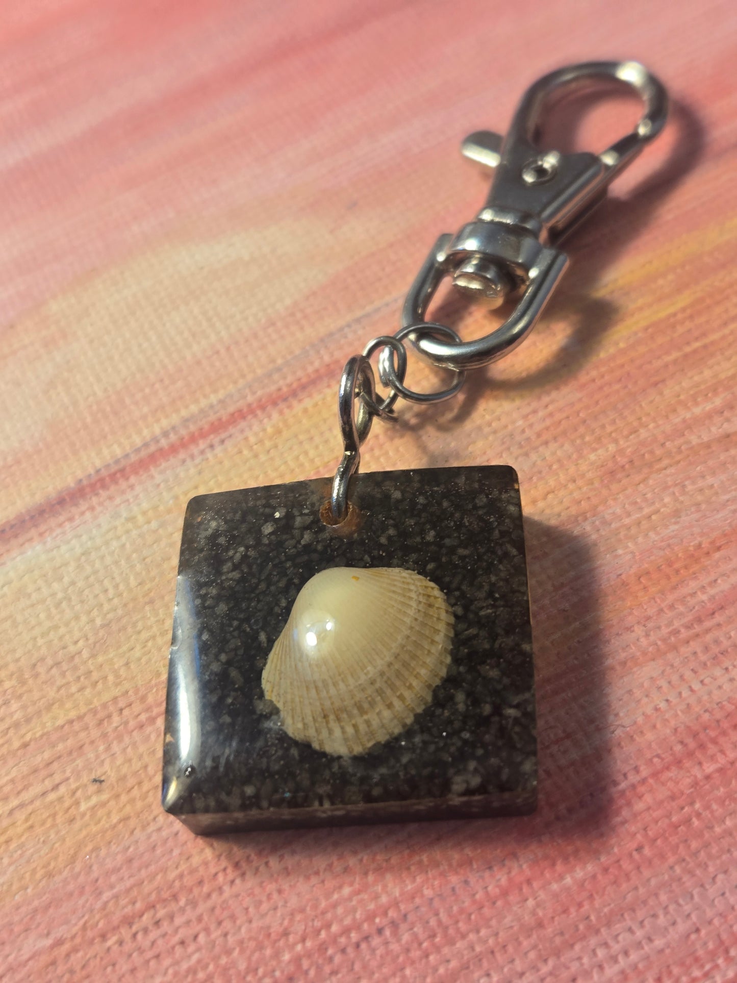 Seashell key chain in black sand